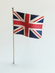 A small British Union Jack flag displayed on a desk stand, symbolizing national pride, patriotism, history, tradition, and heritage., A small British Union Jack flag displayed on a desk stand
