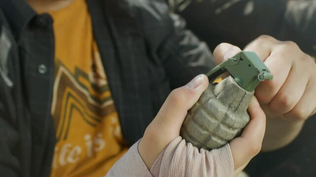 Man in kart pulling pin on grenade then throwing it behind him, closeup