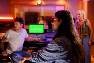 Group of musicians having consultations with sound engineer at recording studio