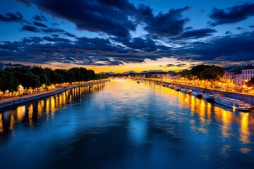 Naklejka premium A sunset view of the RhÃ´ne River, with the lights of Avignon reflecting on the water as boats drift lazily by