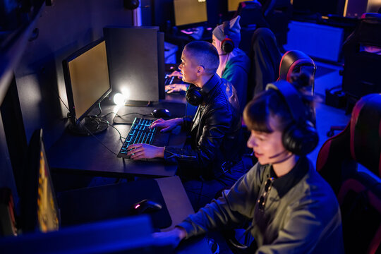 Few gamer girls having lan party in neon lit futuristic cybercafe.
