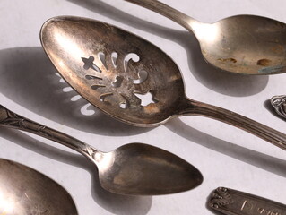 Still life of tarnished silver spoons.