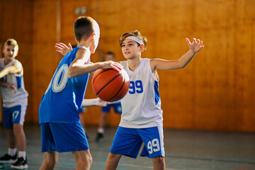 Fototapeta premium Child facing opponent in basketball dribble drill