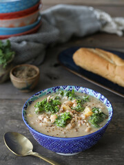 Bowl of soup and bread on a rustic table.