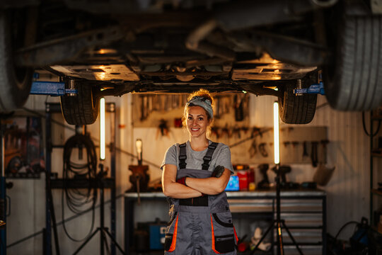 Independent confident female technician at auto mechanic workshop.