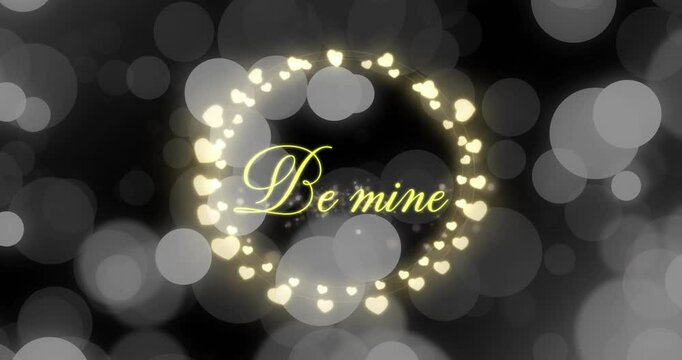 Animation of be mine text over hearts and spots