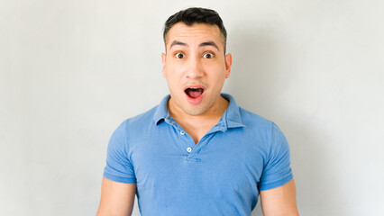 Fototapeta premium Surprised young man striking a pose against a white backdrop
