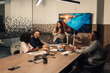 Innovative businesswoman presenting solar panels model to diverse experts
