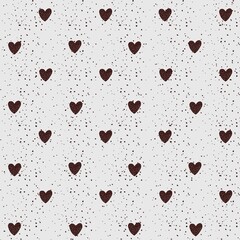 Decorative pattern featuring brown hearts on a light background with speckled details