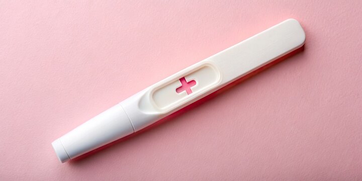 A delicate, white pregnancy test stick with a faint yet unmistakable pink plus sign indication of a positive result, symbols of new life and hope.