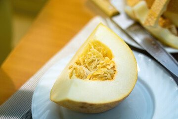 vibrant quarter of a ripe melon rests elegantly on a white ceramic plate, showcasing its bright orange flesh. The composition highlights nature's sweetness and fresh simplicity