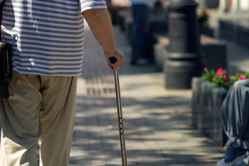 wise old man grips a sleek, adjustable metal cane, symbolizing adaptability and resilience. The...