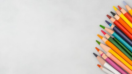 Fototapeta premium A vibrant collection of colored pencils arranged in a semicircle on a grey background, representing creativity, imagination, and the joy of learning.