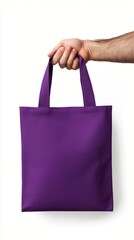 Hand holding vibrant purple reusable shopping tote bag against white background, showcasing...