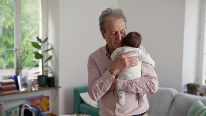 Fototapeta premium Grandfather gently cradling newborn baby in a cozy living room, eyes closed in a moment of affection and bonding, highlighting the warmth of family love and connection