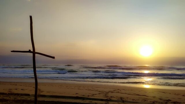 gro&szlig;es h&ouml;lzernes Kreuz am Strand in stimmungsvollem Sonnenuntergang am Horizont, Begr&auml;bnis, Erinnerung, Beisetzung, Trauer, Glaube, Ritual, Symbol, Spiritualit&auml;t, Piet&auml;t