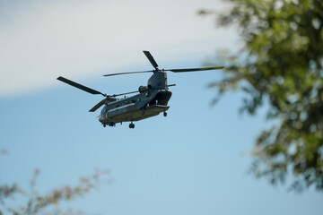 RAF Chinook Tandem Twin Rotor helicopter flying low in a blue sky