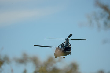 RAF Chinook Tandem Twin Rotor helicopter flying low in a blue sky