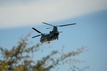 RAF Chinook Tandem Twin Rotor helicopter flying low in a blue sky