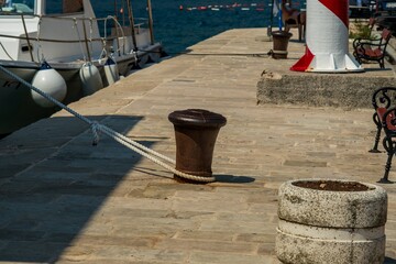 Naklejka premium Harbor dock with mooring bollard and lighthouse