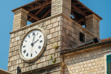 Clock tower with Roman numerals on stone building