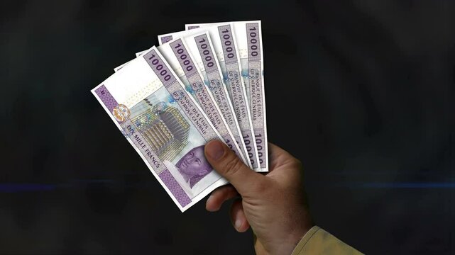 Central African CFA Franc money Cameroon Chad Congo money holding. Fan of banknotes in hand. XAF paper cash. Concept of income, success, business, tax, economy and finance.