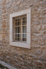 Fototapeta premium Rusty barred window on old stone wall
