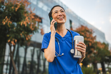 portrait of japanese doctor stand and talk on cellphone on the street