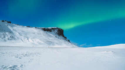 Aurora Borealis in Scandinavia. Northern Lights over the mountains. Winter night landscape with bright lights in the sky. Landscape in the north in winter time. © biletskiyevgeniy