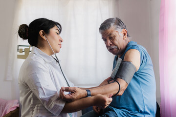 Obraz premium Young nurse performing a health check-up on an elderly patient in a doctor's office.