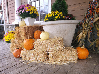 Autumn decoration on the doorstep of the house made of pumpkins, straw and flowers for the...