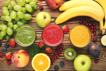 Healthy smoothie in glasses with fruits and vegetable on wooden background