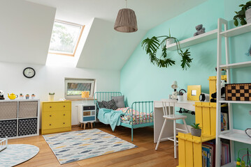 Cozy interior of room child with pastel color on the wall and yellow color in decor. Room in the attic with bed, desk and carpet in modern design. Scandinavian concept.	