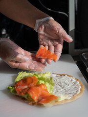 Chef prepares flatbread with salmon. Vertical photo. Quesadilla. 