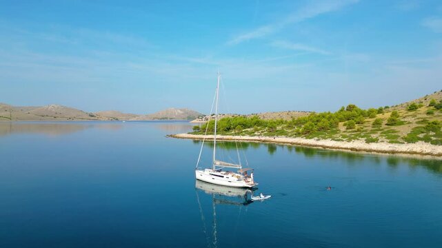An aerial view of a serene bay on Otok Žut, located near the Kornati Islands in Croatia. The bay, surrounded by lush greenery and rocky shores, offers a tranquil retreat in the Adriatic Sea