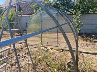 Installation of a metal frame greenhouse with polycarbonate covering