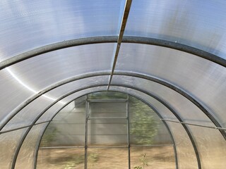 Fototapeta premium Installation of a metal frame greenhouse with polycarbonate covering