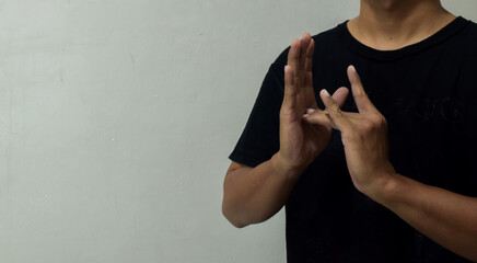 young man showing word jesus using sign language to communicate © syahrir