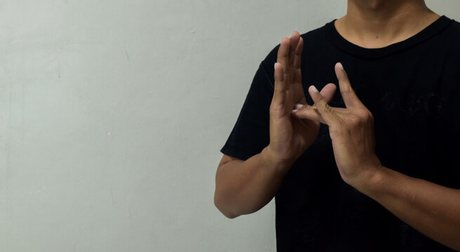 young man showing word jesus using sign language to communicate