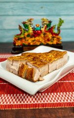 pork crackling cut into pieces, served on a plate