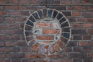 Old stained brick wall of an industrial building, round porthole window bricked in, creative copy...