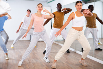 Fototapeta premium Group of positive dancers repeat dance in dance hall