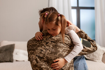 military man of the Ukrainian army in camouflage uniform returned home and hugs his daughter, soldier goes to war and says goodbye to his child, the concept of mobilization in Ukraine