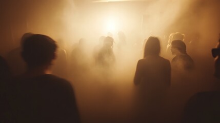A crowd of people in a foggy space illuminated by a bright light, creating a party atmosphere.