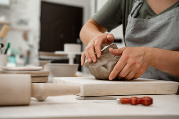 Wedging the clay before starting making a pottery project to create proper consistency. Removing...