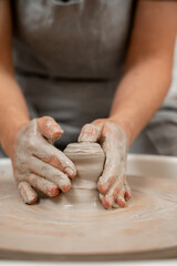 Fototapeta premium Forming the proper size and shape of pottery with increasing speed of a pottery wheel. Making a bowl on a pottery wheel with your own hands.