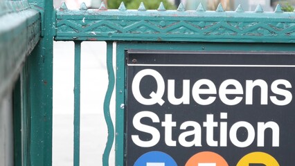 New York subway sign, Queens underground metro station. Metropolitan entrance fence, public transport exit. Long Island city street, NYC United States. Navigation text on signboard. Pedestrians people