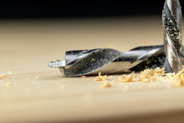 metal drill bit and pine wood board during operation