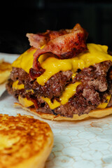 cheff making a doble cheese burger with bacon