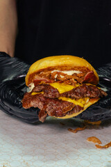 cheff making a doble cheese burger with bacon